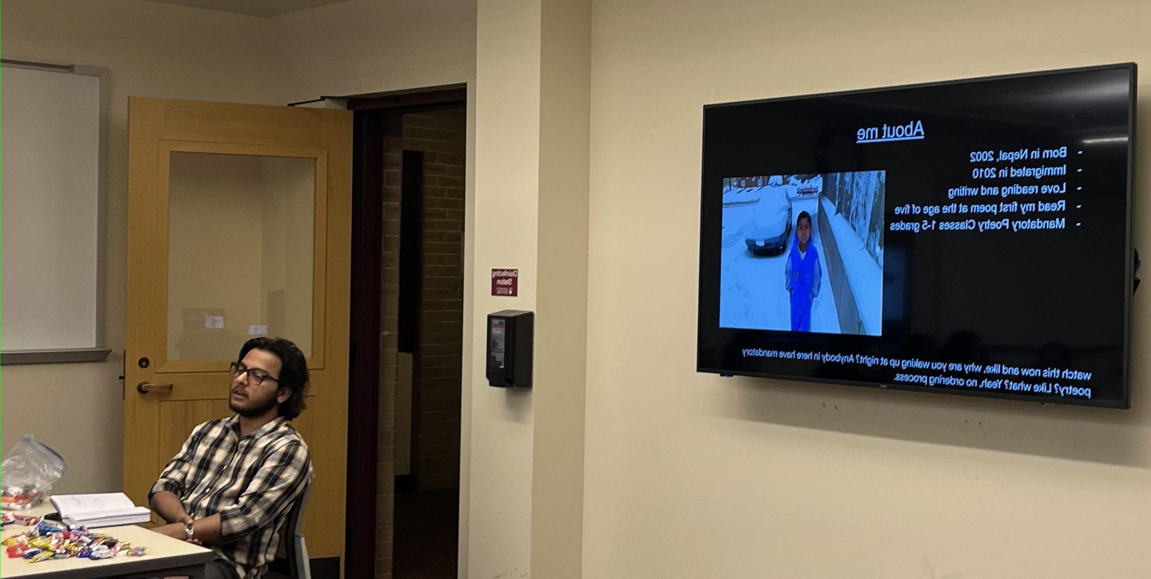 man teaching class with powerpoint slide on display behind him